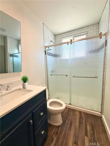 a bathroom with a granite countertop sink toilet and shower
