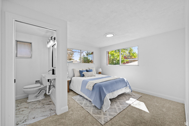 2267 West 4350th Street South Roy, UT 84067 - Photo 13 of 32 Bedroom with multiple windows, ensuite bath, a textured ceiling, and light carpet