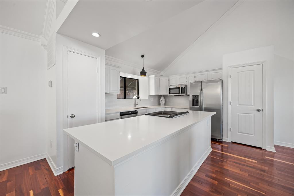 5422 Ranger Drive Rockwall, TX 75032 - Photo 13 of 32 a kitchen with a sink a stove a refrigerator and white cabinets