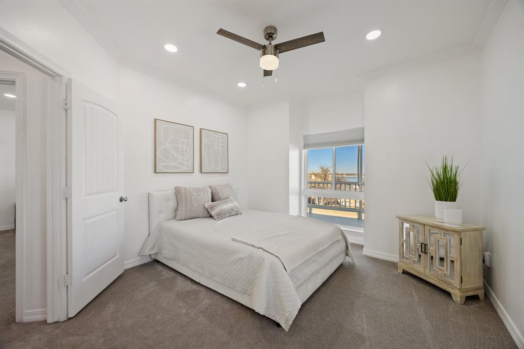 5422 Ranger Drive Rockwall, TX 75032 - Photo 22 of 32 a bedroom with a large bed and a chandelier fan