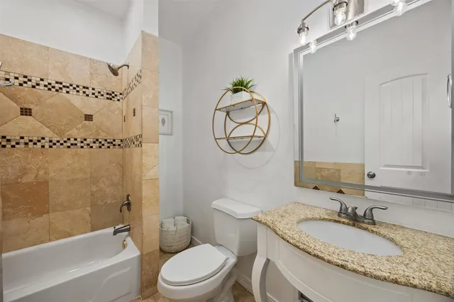 a bathroom with a granite countertop toilet a sink and a mirror