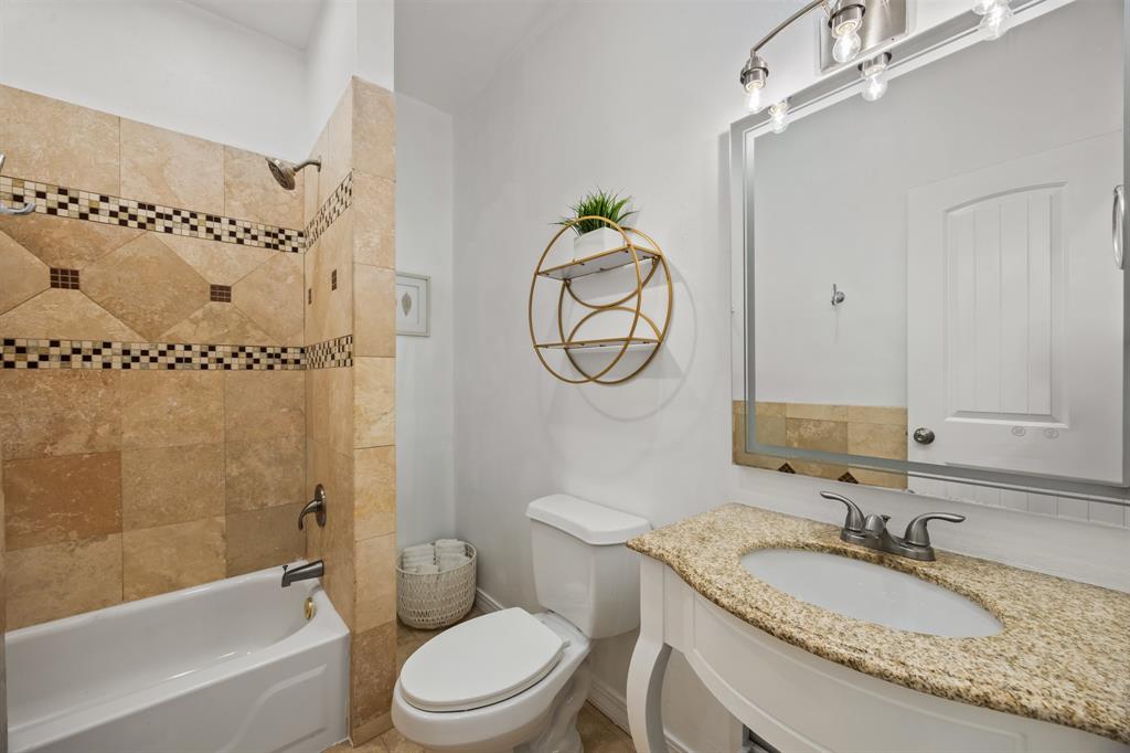 5422 Ranger Drive Rockwall, TX 75032 - Photo 23 of 32 a bathroom with a granite countertop toilet a sink and a mirror