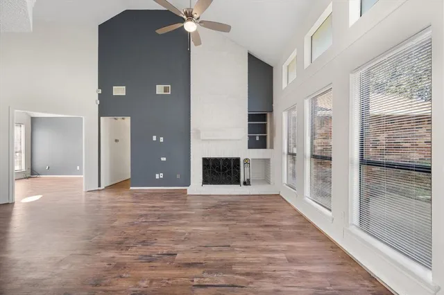 a view of a livingroom with wooden floor a fireplace and window