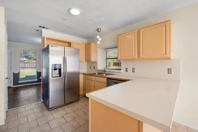 a kitchen with stainless steel appliances a refrigerator sink and cabinets