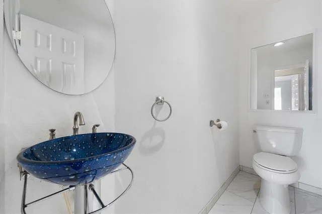 a bathroom with a toilet a sink and a mirror