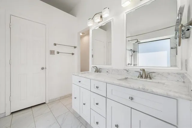 a bathroom with a granite countertop sink mirror and cabinets