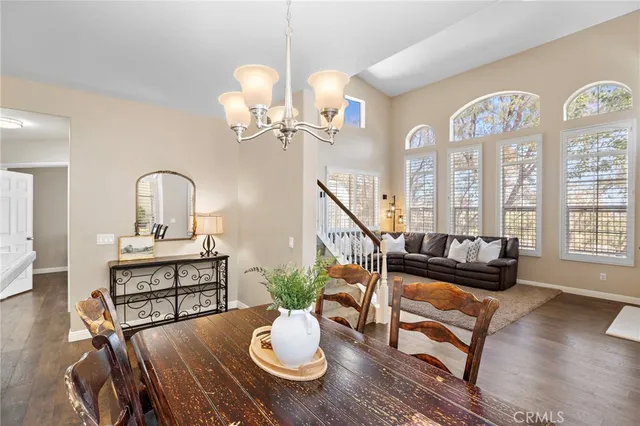 a view of a dining room with furniture a chandelier and wooden floor