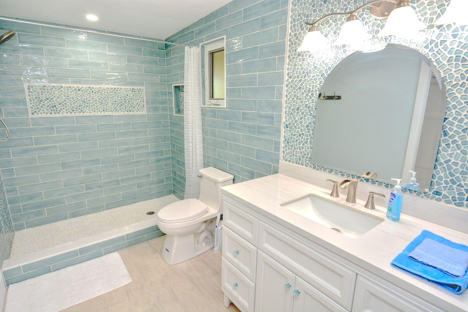 1315 Northeast Flora Place Jensen Beach, FL 34957 - Photo 18 of 27 a bathroom with a sink a toilet and shower