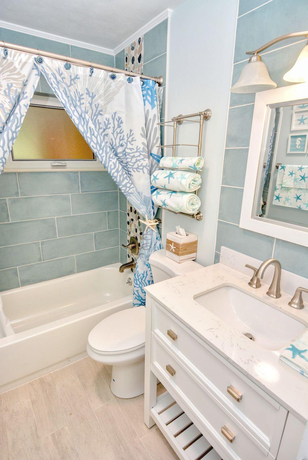 1315 Northeast Flora Place Jensen Beach, FL 34957 - Photo 24 of 27 a bathroom with a sink a toilet and a bathtub