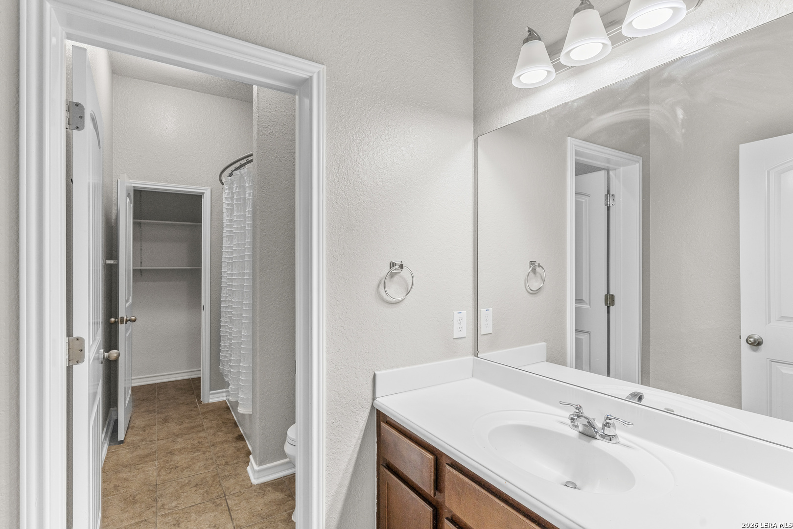 10421 Macarthur Way Converse, TX 78109 - Photo 24 of 26 a bathroom with a sink and a mirror