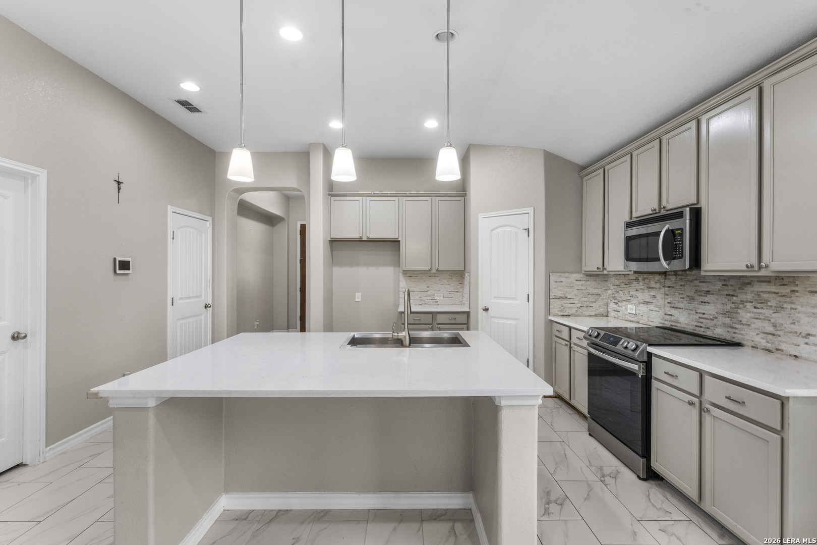 10421 Macarthur Way Converse, TX 78109 - Photo 8 of 26 a kitchen with kitchen island a sink stainless steel appliances and cabinets