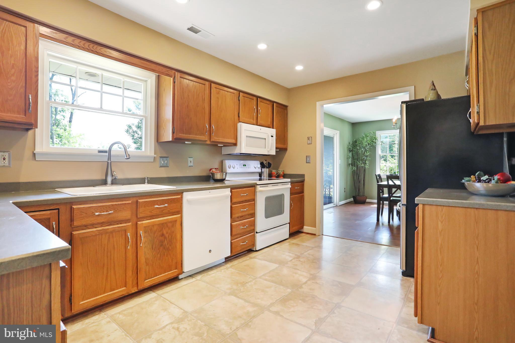 1603 Gibbons Road Point of Rocks, MD 21777 - Photo 9 of 29 a kitchen with stainless steel appliances granite countertop a refrigerator a sink dishwasher a stove a dining table and chairs with wooden floor