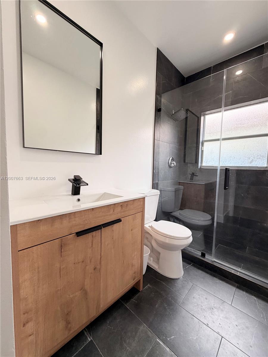 86 Northwest 4th Street Homestead, FL 33030 - Photo 18 of 22 a bathroom with a toilet sink and mirror