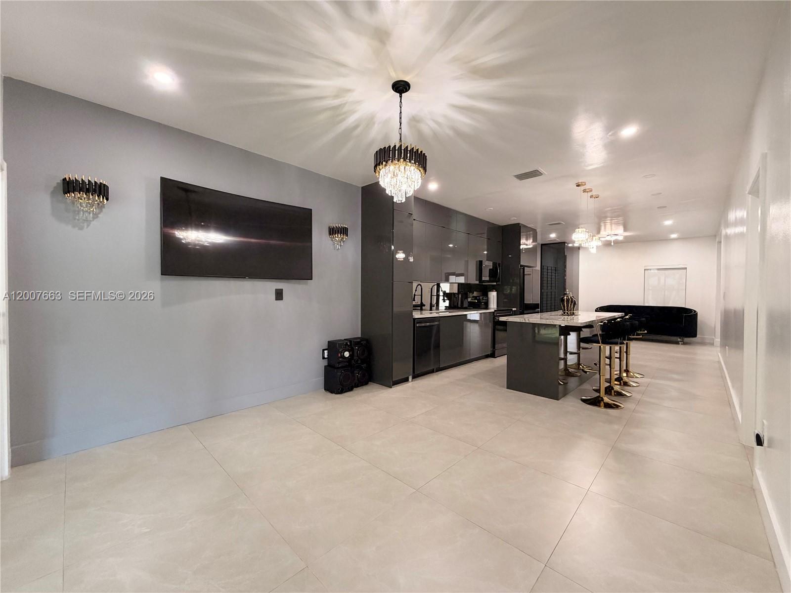 86 Northwest 4th Street Homestead, FL 33030 - Photo 7 of 22 a view of a kitchen with furniture and a flat screen tv
