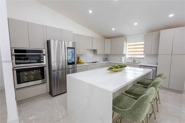 a kitchen with stainless steel appliances a refrigerator a stove a sink and a refrigerator