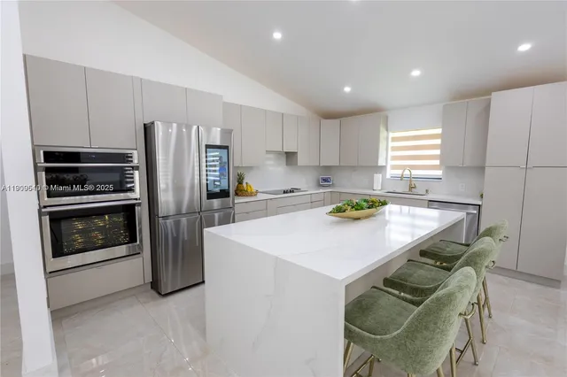 a kitchen with stainless steel appliances a refrigerator a stove a sink and a refrigerator