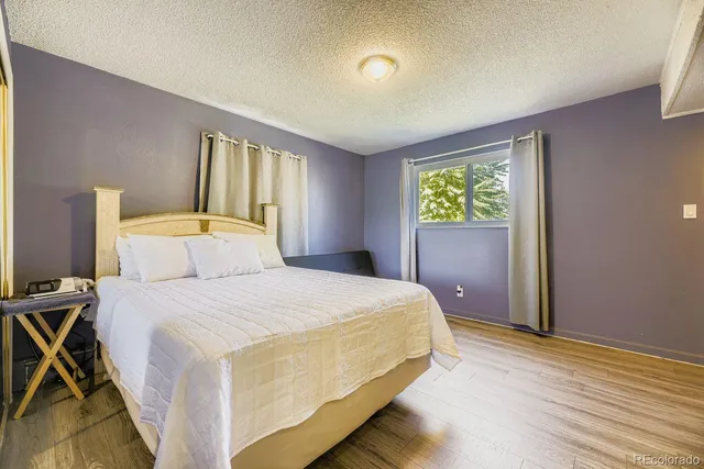 a bedroom with a bed and wooden floor