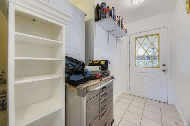 a view of a backyard with table and chairs potted plants and a large tree