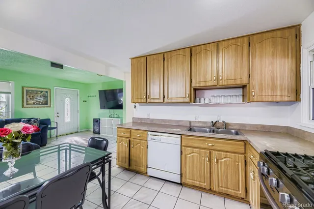 a kitchen with stainless steel appliances granite countertop a stove top oven a sink dishwasher with a dining table and chairs