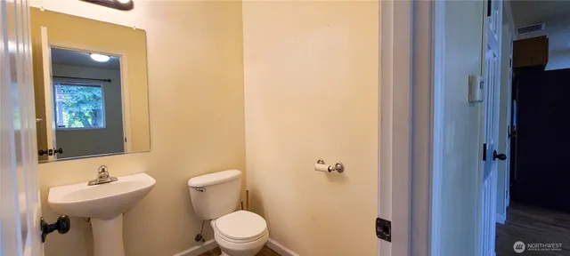 a bathroom with a toilet sink and mirror