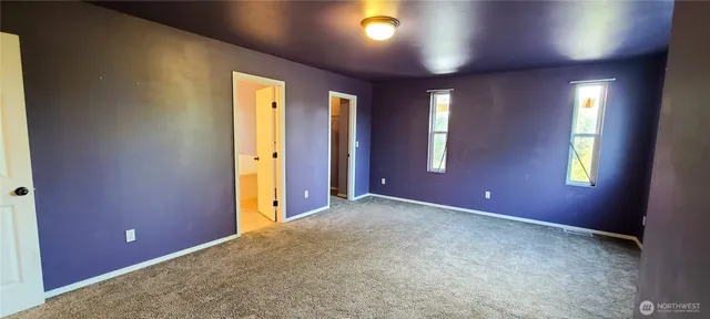 an empty room with windows and closet