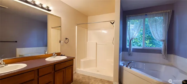 a bathroom with a granite countertop sink and a bathtub