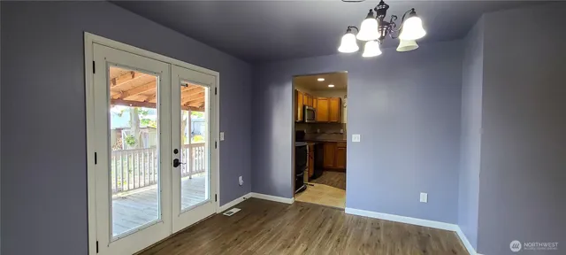 a view of a livingroom with a chandelier wooden floor and front door