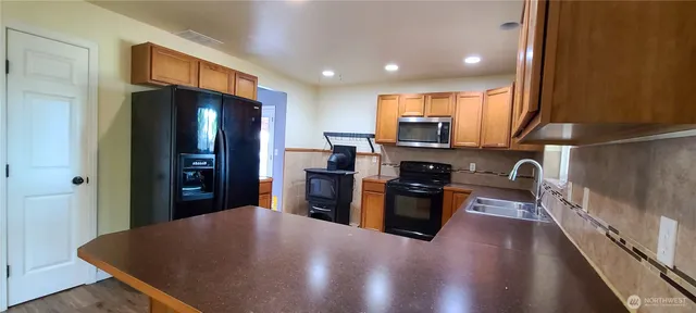 a kitchen with stainless steel appliances granite countertop a refrigerator stove top oven a sink and dishwasher