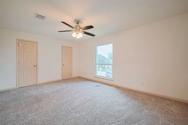 a view of an empty room with a ceiling fan