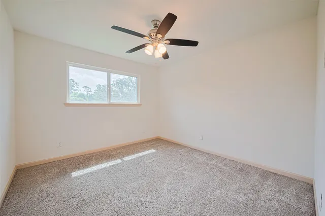 an empty room with closet and ceiling fan
