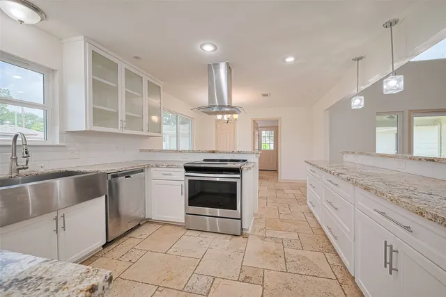 a large kitchen with granite countertop a stove and a sink