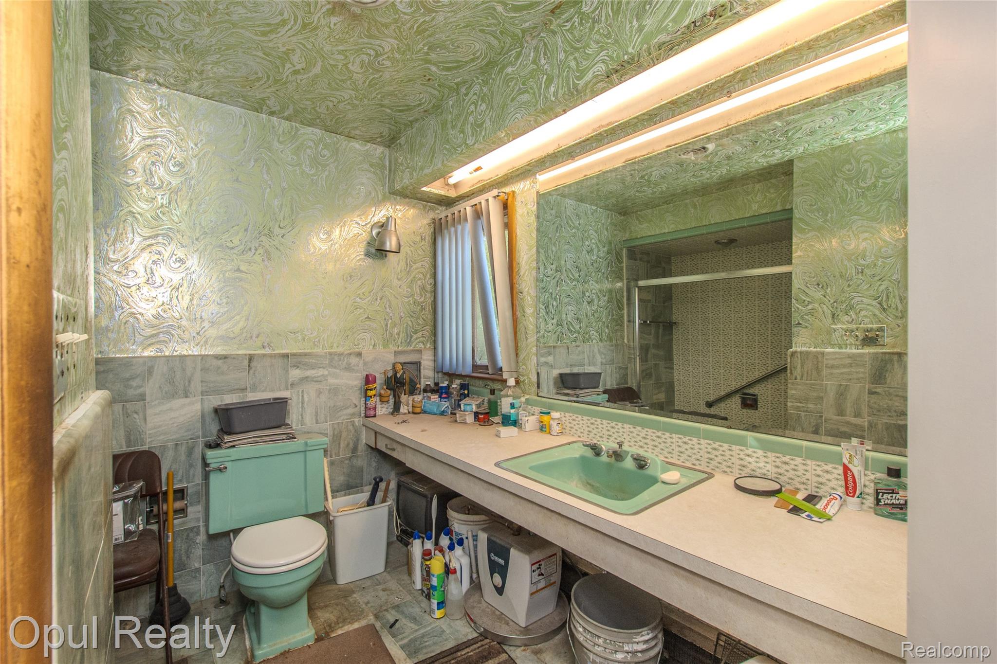 6455 Norham Road Bloomfield Hills, MI 48301 - Photo 53 of 93 Bathroom featuring a built-in vanity with a green basin sink, a large wall-mounted mirror, overhead fluorescent lighting, and a green toilet