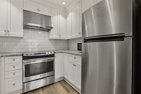 a kitchen with a refrigerator and a stove top oven