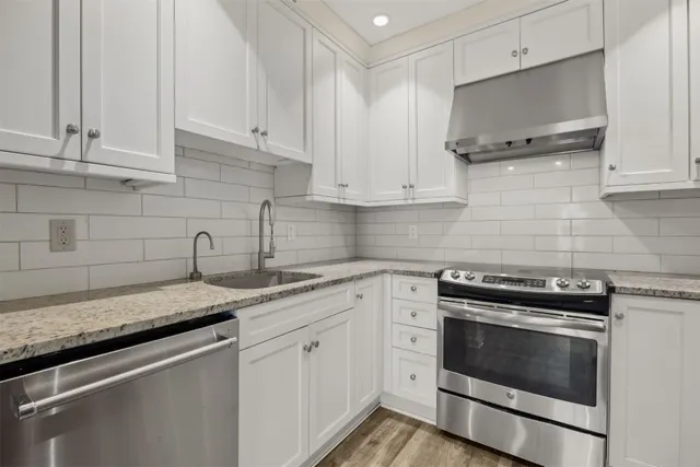 a kitchen with granite countertop white cabinets and white appliances