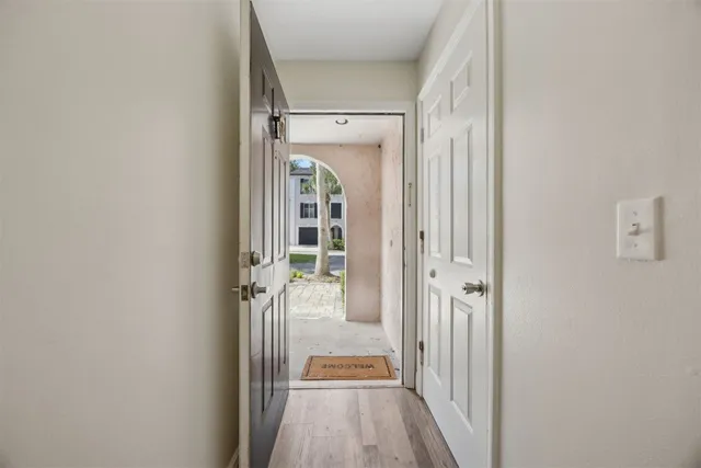 a view of a hallway with wooden floor and staircase