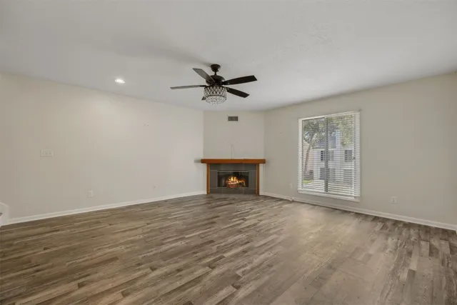 a view of an empty room with a fireplace and a window