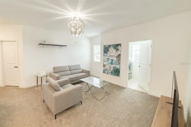 a living room with furniture a chandelier and a dining table