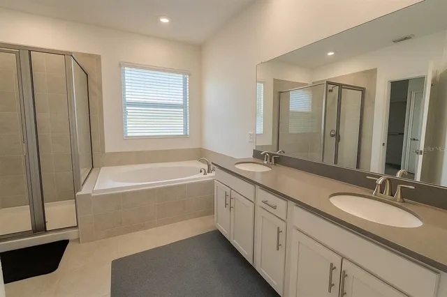 a bathroom with a granite countertop sink mirror and a bathtub