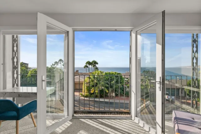 a bedroom with furniture and a large window with balcony view