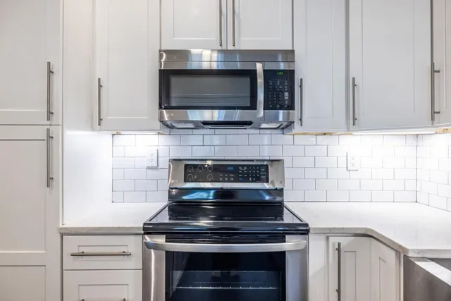 a stove top oven sitting inside of a kitchen