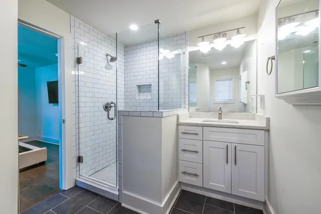 a bathroom with a shower sink and mirror