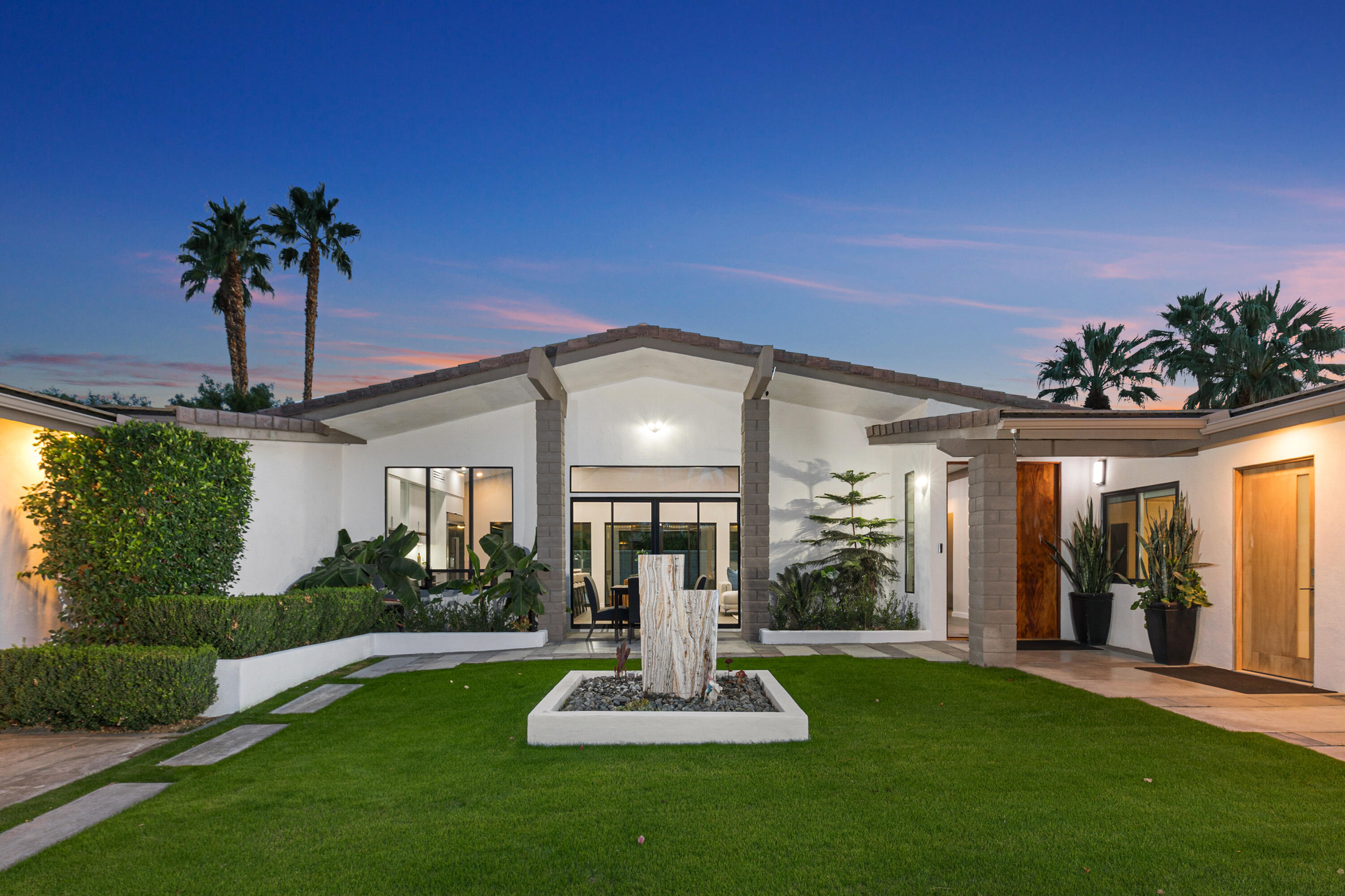 a view of a house with porch and garden
