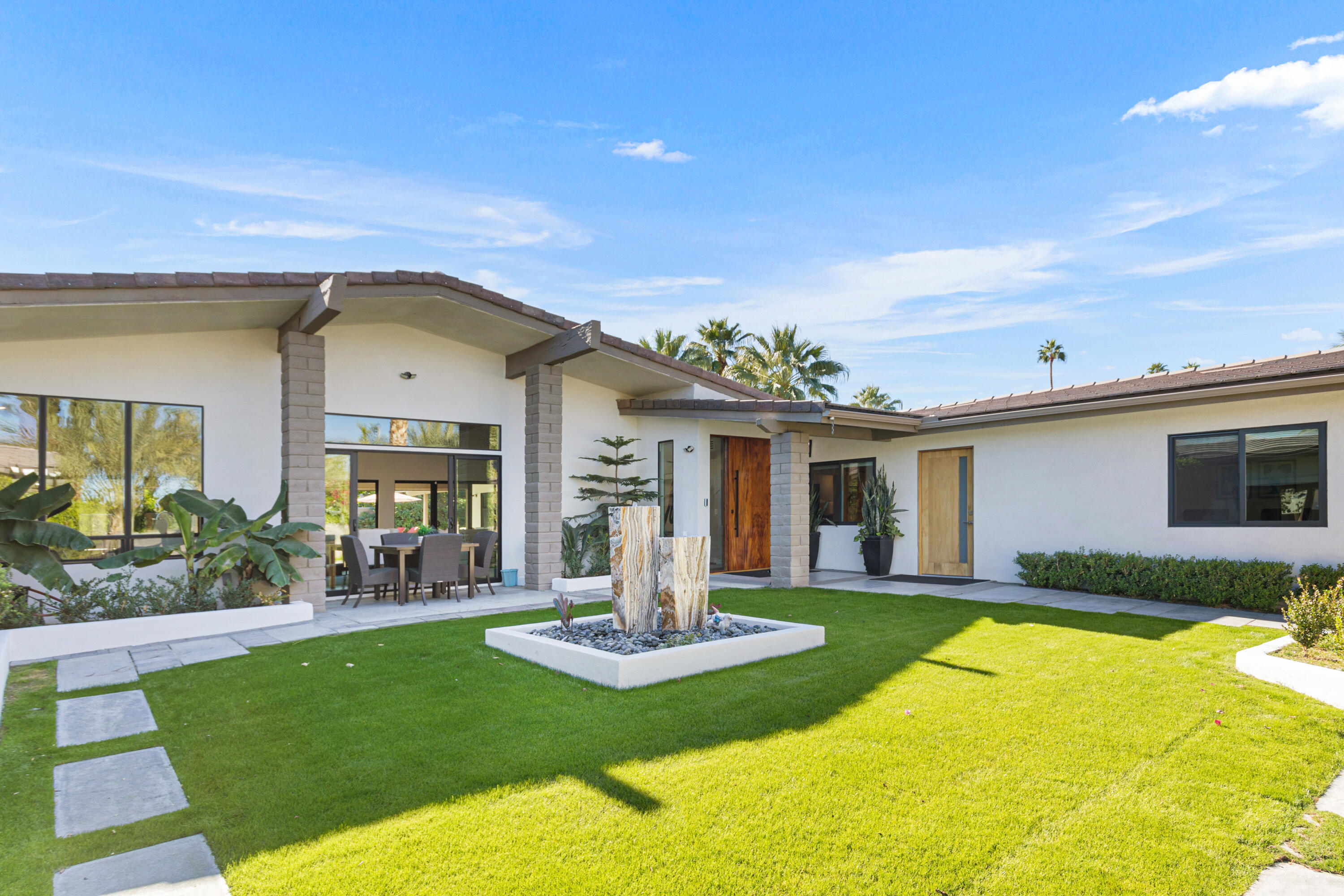 74155 Mockingbird Trail Indian Wells, CA 92210 - Photo 11 of 55 a front view of a house with yard and green space