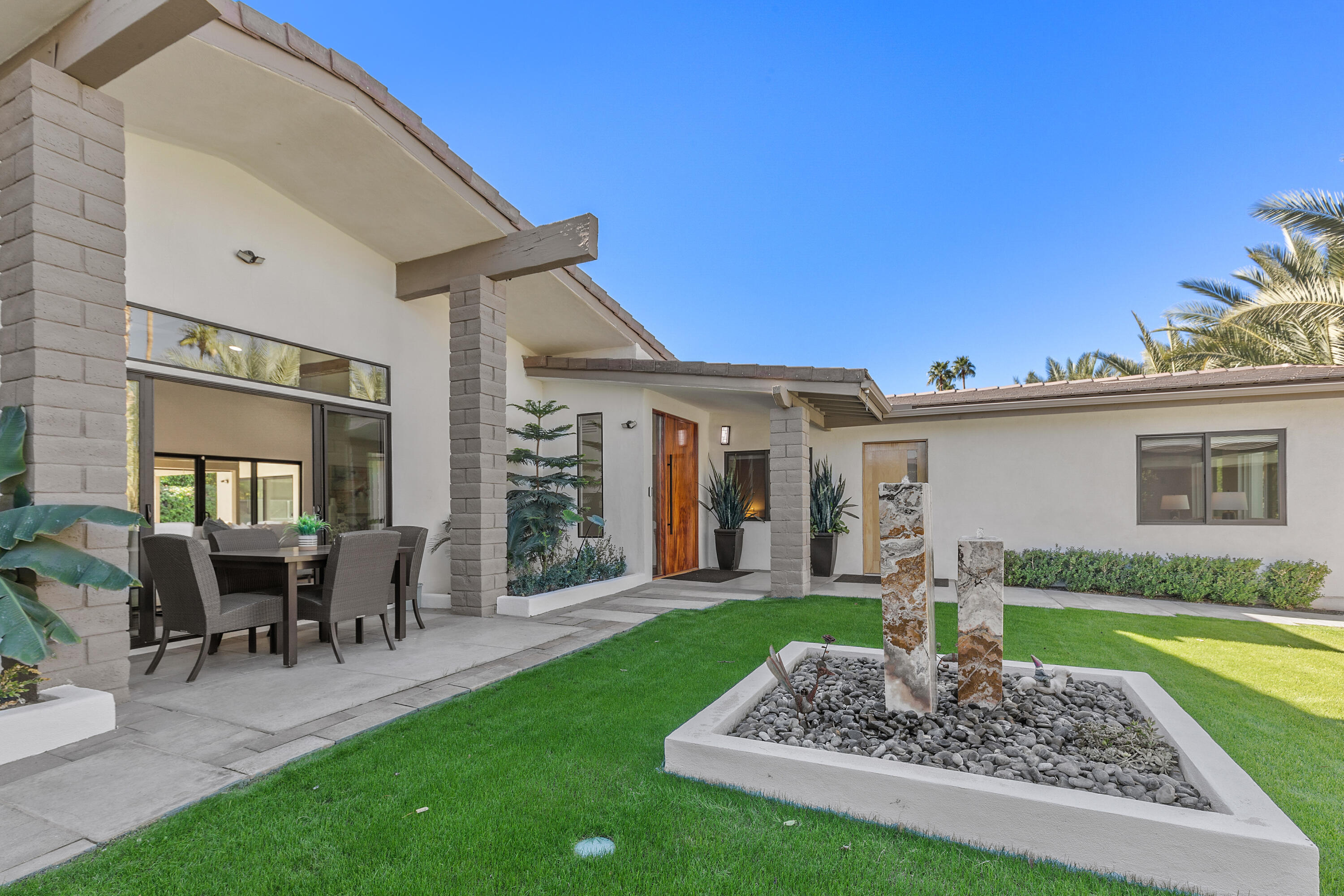 74155 Mockingbird Trail Indian Wells, CA 92210 - Photo 12 of 55 a front view of a house with a yard table and chairs