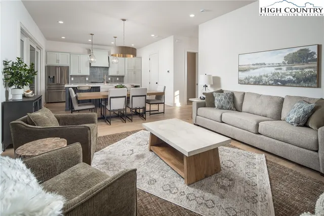 a large kitchen with kitchen island granite countertop a table chairs sink and cabinets