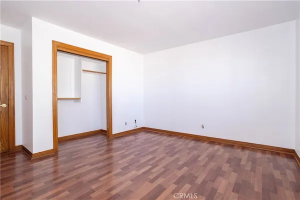 an empty room with wooden floor and closet