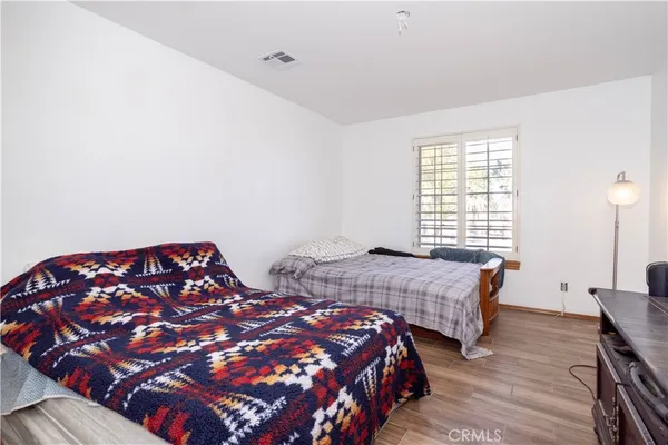 a bedroom with two beds and wooden floor