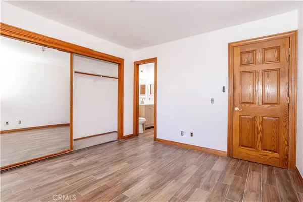 an empty room with wooden floor and closet