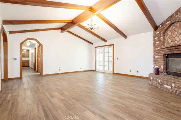 a view of a livingroom with wooden floor and a fireplace