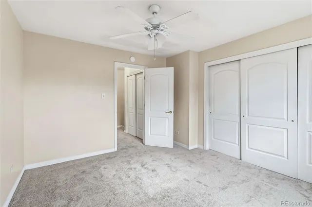 a view of an empty room and chandelier fan